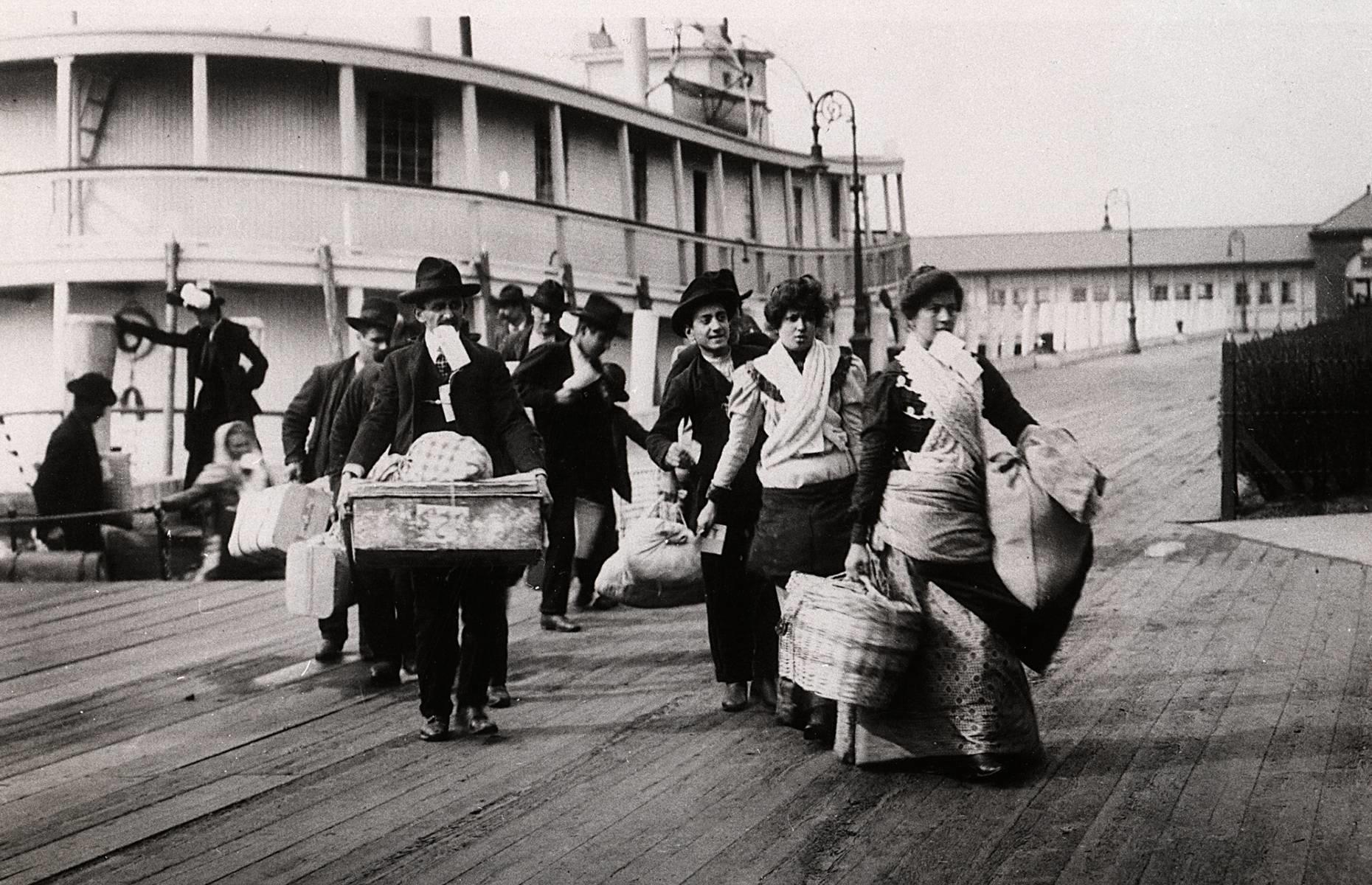 1900: Immigrants arriving at Ellis Island